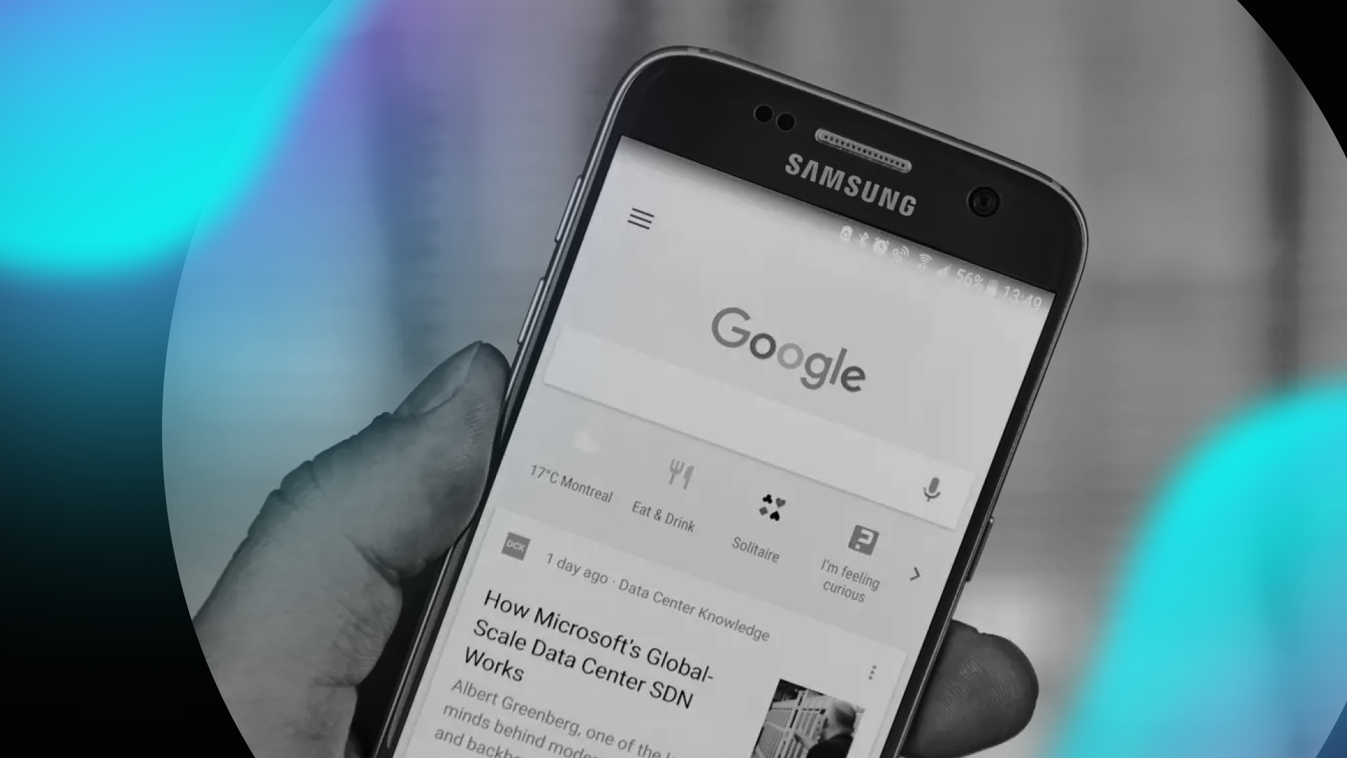 A hand holds a Samsung smartphone displaying the Google homepage, with news articles and updates—ideal inspiration for any web design agency. The image features a black and white filter with a blue gradient overlay on the left side.